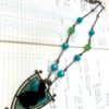 Black resin cast rabbit crest necklace with blue and green beads